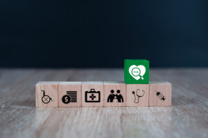 Wooden toy blocks stacked with medical icon for medical and health insurance concepts.